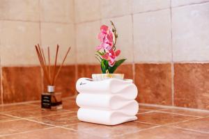 a white vase with flowers in it on a counter at Philoxenia House in Sidirokastro +16 photos