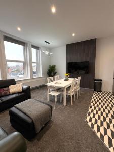 a living room with a table and a couch at Spacious 4 Bed Retreat, 2 Bath, Sleeps 8 plus 2, Beach, Bars, Dinning, Shops, Golf, for Groups, Contractors or Families in Bournemouth