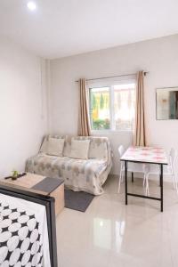 a living room with a couch and a table at Yada House s&h in Nai Yang Beach