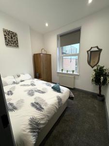 a bedroom with a bed and a window at Spacious 4 Bed Retreat, 2 Bath, Sleeps 8 plus 2, Beach, Bars, Dinning, Shops, Golf, for Groups, Contractors or Families in Bournemouth