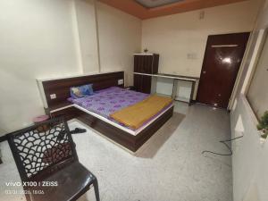 a small bedroom with a bed and a chair at HOTEL VISAVA GARDEN & LODGINg in Vaghunde Budrukh