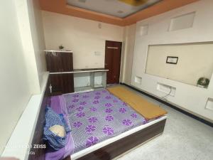 a room with a bed with a purple carpet at HOTEL VISAVA GARDEN & LODGINg in Vaghunde Budrukh
