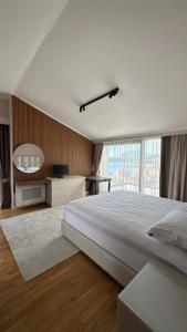 a bedroom with a large bed and a large window at Perla Petrus in Rafailovici