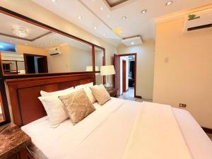 a bedroom with a large white bed with pillows at EXECUTIVE SUITE Piscina & Parking Privado in Machala +26 photos