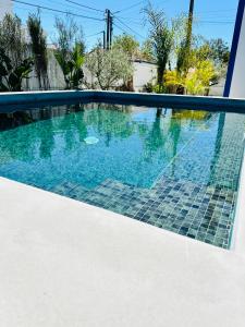 ein Swimmingpool in einem Haus mit blauem Wasser in der Unterkunft Maison Comporta in Comporta