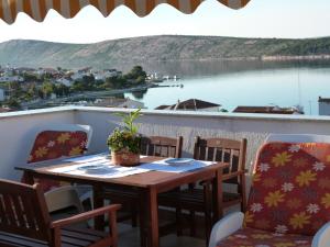 a table on a balcony with a view of a lake at Apartment Barbat 7 in Barbat na Rabu
