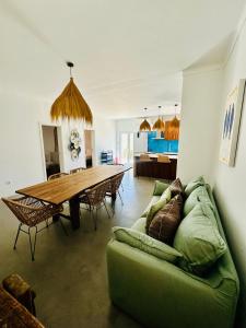 ein Wohnzimmer mit einer grünen Couch und einem Holztisch in der Unterkunft Maison Comporta in Comporta