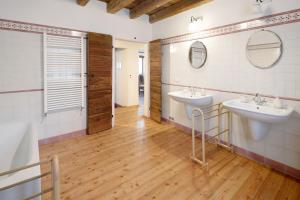 a bathroom with two sinks and two mirrors at Agriturismo Marzanino in Torre di Mosto +41 photos