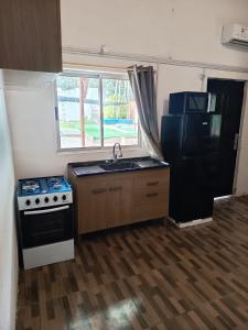 a kitchen with a stove and a sink and a refrigerator at Cordero Atado Hotel Apart in Ocean Park