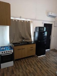 a kitchen with a stove and a refrigerator at Cordero Atado Hotel Apart in Ocean Park +3 photos