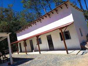 a white house with a red roof at Cordero Atado Hotel Apart in Ocean Park
