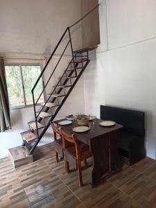 a dining room with a table and a spiral staircase at Cordero Atado Hotel Apart in Ocean Park