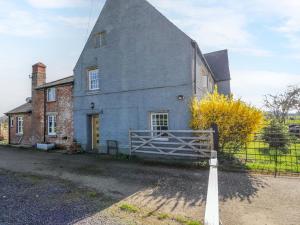 an old house with a fence in front of it at 3 Woods Farm House in Chippenham