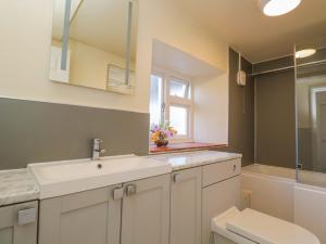 a bathroom with a sink and a toilet and a window at 3 Woods Farm House in Chippenham +26 photos
