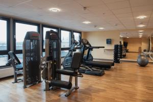a gym with treadmills and exercise equipment in a building at Home Hotel Bristol in Arvika