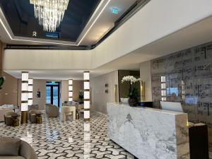 a lobby with a reception desk and a chandelier at Aria Palace by OMNIA hotels in Rome