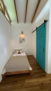 a bedroom with a bed and a blue door at Casa Yami Lodge in Fortuna