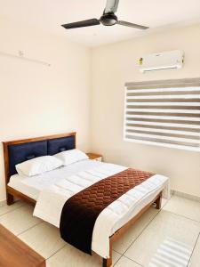 a bedroom with a large bed with a ceiling fan at JK Homes in Alwaye