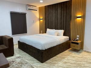 a bedroom with a large bed with a wooden headboard at House 2 Guest House - Felele in Ibadan