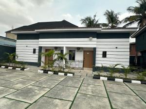 a white house with palm trees in front of it at House 2 Guest House - Felele in Ibadan