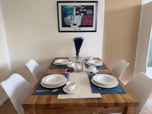 a dining room table with white plates and chairs at Ferienwohnungen First Bismarck in Bad Pyrmont