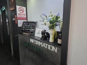 a cat figurine sitting on top of a counter with flowers at Bucheon The Seollelm Hotel Stay in Bucheon