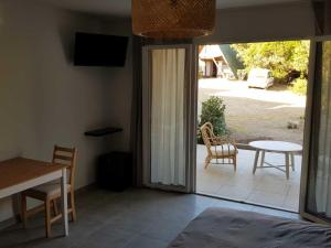 a bedroom with a door open to a patio with a table at les terrasses d'arutoli in Porto-Vecchio +2 photos