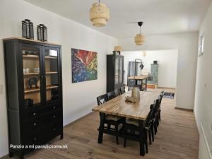 a dining room with a wooden table and chairs at vendégház A Mi Paradicsomunk in Palotabozsok