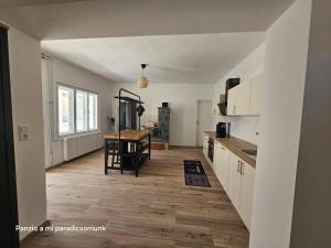 a kitchen with a wooden floor and a table at vendégház A Mi Paradicsomunk in Palotabozsok +6 photos