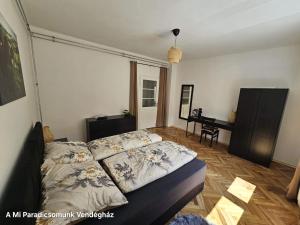 a bedroom with a bed and a desk with a piano at vendégház A Mi Paradicsomunk in Palotabozsok