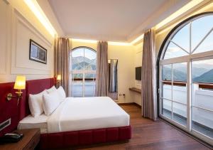 a hotel room with a bed and a large window at Saltstayz Autograph - Rishikesh Near Triveni Ghat in Rishīkesh
