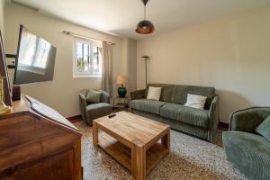 a living room with a couch and a coffee table at Maison Pamplemousse in Arles