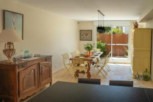 a living room with a table and a dining room at Maison Pamplemousse in Arles