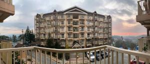 a large building is shown from a balcony at MGs Dwell - Baguio Transient at Moldex Residences in Baguio