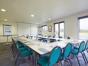a large room with a long table and chairs at Campanile Lens in Lens