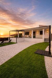 a house with a green lawn in front of it at Mirage Luxury Living in Nea Potidaea