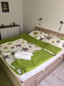 a bed with a green comforter and stars on it at ZEN Apartman Sunshine in Zamárdi