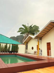 a swimming pool in front of a house at Khaosok Embrace Resort in Khao Sok National Park