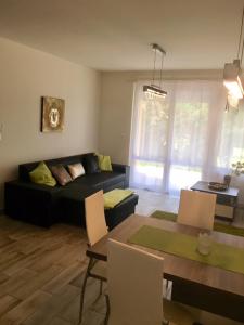 a living room with a couch and a table at ZEN Apartman Sunshine in Zamárdi