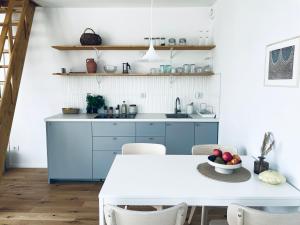 a kitchen with blue cabinets and a white table at Skrzydła Biebrzy- Eco Cottage nad rzeką Narwią - Biebrza NP in Niwkowo +31 photos