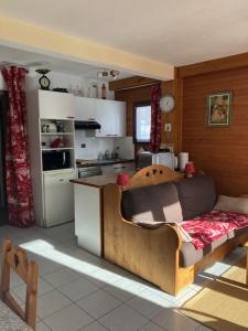 a kitchen with a couch in the middle of a room at Appartement les Carroz d'Arraches in Les Carroz d'Araches