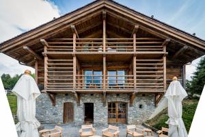 a large wooden building with chairs in front of it at Zannier Le Chalet in Megève