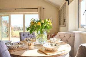 a dining room with a table with a vase of flowers at Host & Stay - Mole Cottage in Swannington