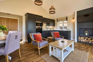 a living room with chairs and a table and a kitchen at Host & Stay - Mole Cottage in Swannington