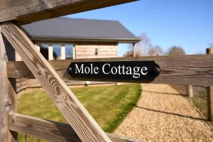 a wooden fence with a sign that reads mole cottage at Host & Stay - Mole Cottage in Swannington