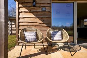 two wicker chairs sitting on a porch at Host & Stay - Mole Cottage in Swannington