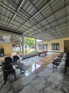 a large room with chairs and tables and windows at d'Alvin Homestay in Labuan Bajo