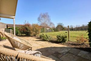 a wicker chair sitting on the porch of a house at Host & Stay - Toad Cottage in Swannington