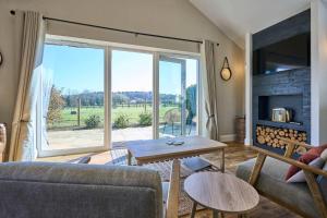 a living room with a fireplace and a large window at Host & Stay - Toad Cottage in Swannington