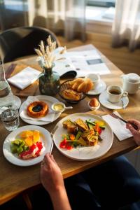 a person sitting at a table with plates of food at Hotel Turiec in Martin